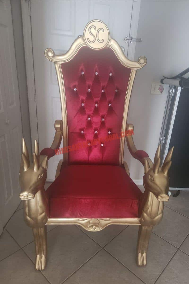 Santa photo session in Cape Coral, FL: gold Santa chair with a red tufted back and gift boxes.