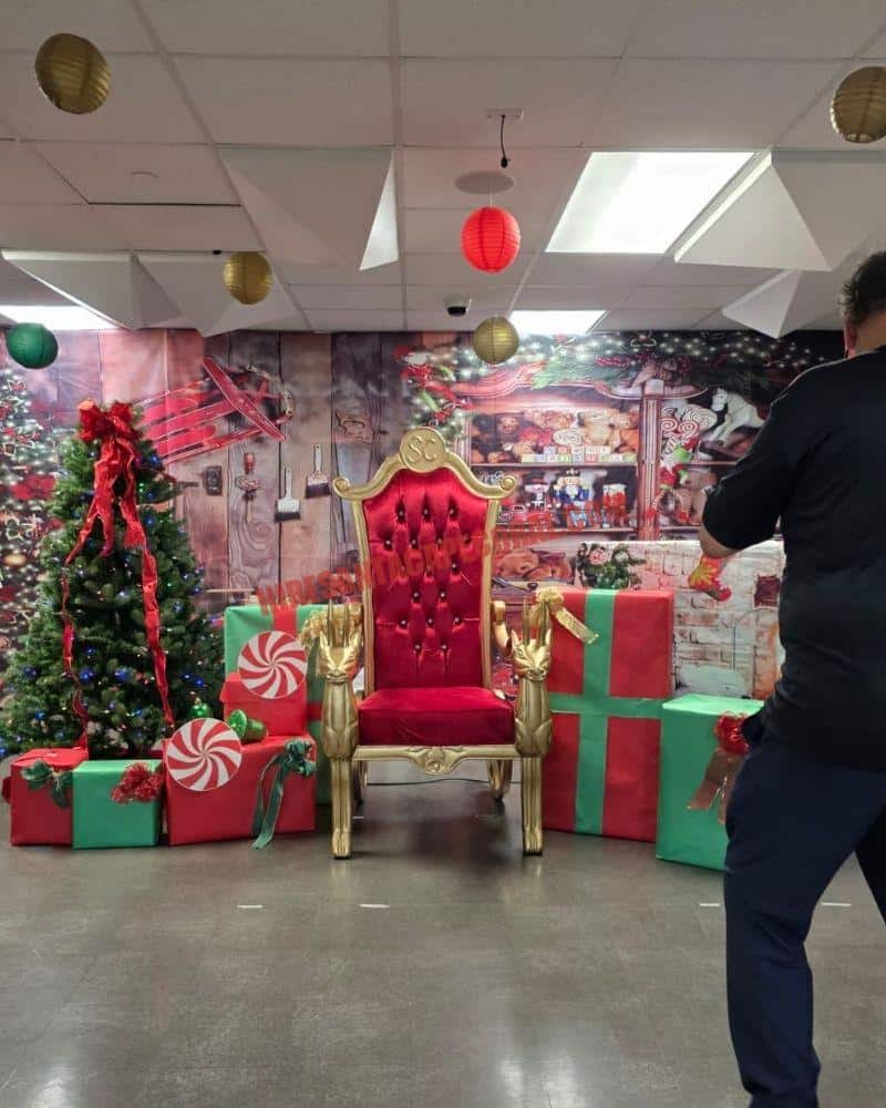 Santa photos in Cape Coral, FL: a Santa chair with gift boxes and a lit tree in an indoor set.