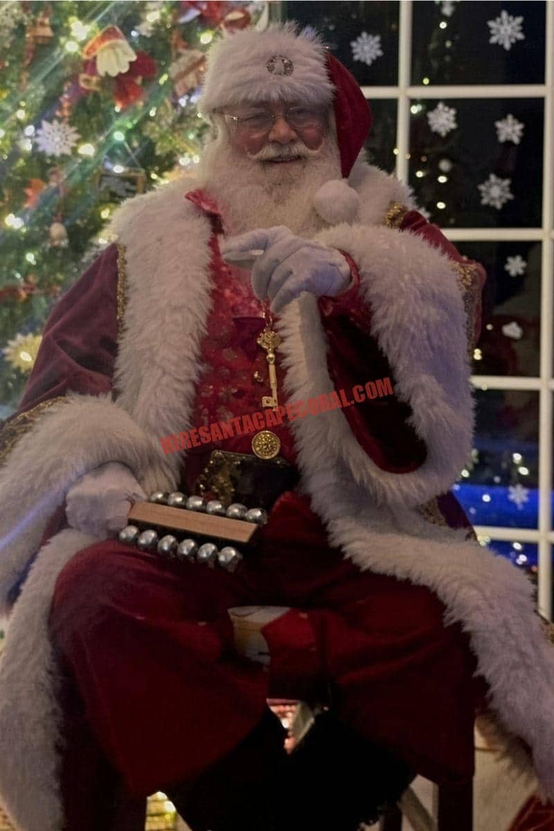 Santa home visit in Cape Coral, FL: Santa seated by a night window holding sleigh bells and a gold key.